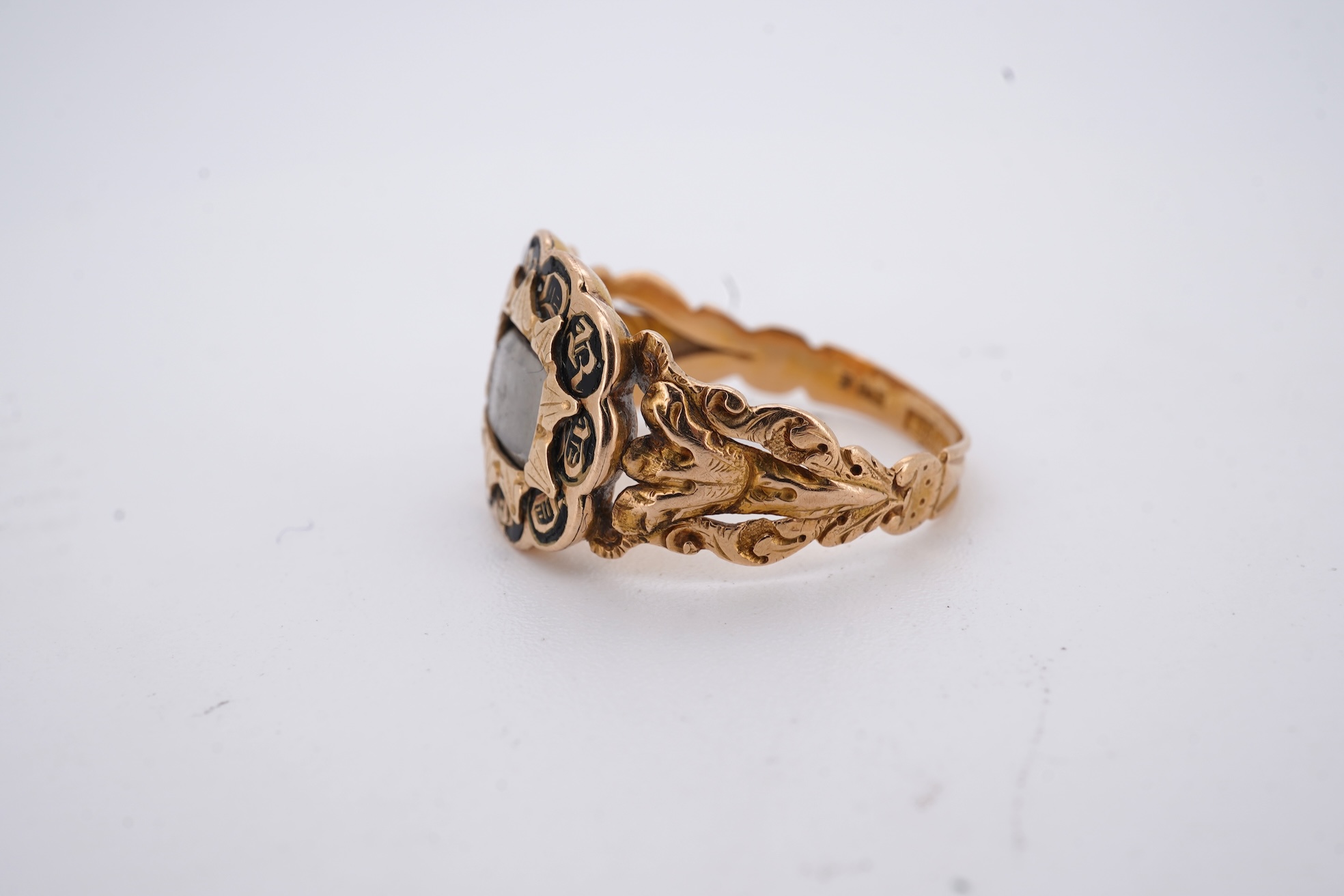 A William IV 18ct gold and black enamel 'In Memory' mourning ring, with hair beneath a central glazed panel, size N, gross weight 2.8 grams.